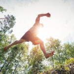 Young man jumping in the forest 